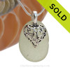 A  perfect piece of larger seafoam green  genuine sea glass with a solid sterling bail and detailed heart in hearts charm.
