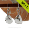 Airy and light pure white sea glass earrings in sterling with sterling dolphin charms.