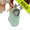 Stunning glowing Tropical Long Aqua Green genuine sea glass with a solid sterling bail and detailed heart in hearts charm.