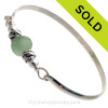 Perfect Sea Green English Sea Glass combined with two Sterling Dolphin Beads on this Solid Sterling Silver Premium Sea Glass Bangle Bracelet.