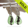 Natural  green sea glass pieces are set with solid sterling seahorse charms and are presented on sterling silver fishook earrings.

