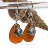 Natural glowing amber brown sea glass pieces are set with solid sterling sea shell charms and are presented on sterling silver fishook earrings.