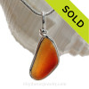 A once in a lifetime piece of orange sea glass is set in our Original Wire Bezel© pendant setting.