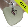 A lovely piece of natural seafoam green sea glass set on a solid sterling hand cast bail with a sterling silver heart red enameled heart charm. A perfect sea glass necklace for any sea glass lover!