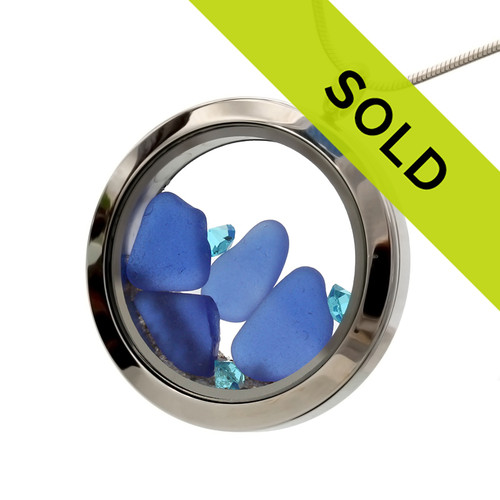 Blue natural sea glass are combined with Zircon crystal gemstones in a stainless steel locket.
Real beach sand completes your own personal "Beach On The Go"!
Zircon is the December Birthstone!
SORRY THIS PIECE HAS SOLD!