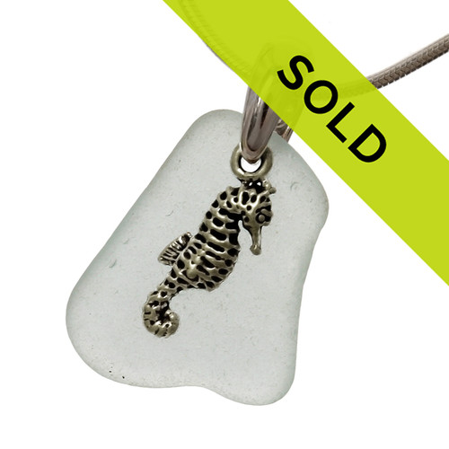A nice piece of quality very pale aqua green sea glass in a simple setting of sterling that leaves much of the glass exposed.

This solid sterling bail and solid sterling seahorse charm give it that beachy look. 

Sorry this piece has sold!