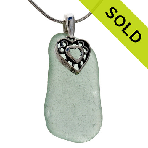 A large piece of natural seafoam green sea glass set on a solid sterling hand cast bail with a sterling silver heart in hearts charm. 
Sorry this Sea Glass Necklace is NO LONGER AVAILABLE.