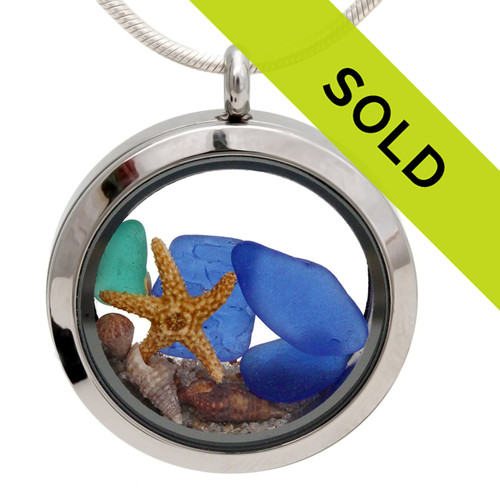 A very rare electric aqua green and blue sea glass pieces combined with a real starfish, tiny shells and beach sand in this sea glass locket necklace.
Sorry this sea glass jewelry piece has sold!