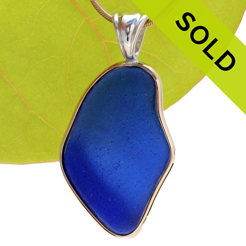 A HUGE piece of rich cobalt blue sea glass set in our classic and elegant Tiffany Deluxe Wire Bezel setting in a mixture of gold and silver. This setting leaves the sea glass piece totally UNALTERED from the way it was found on the beach.
Sorry this one of a kind sea glass pendant has been sold!