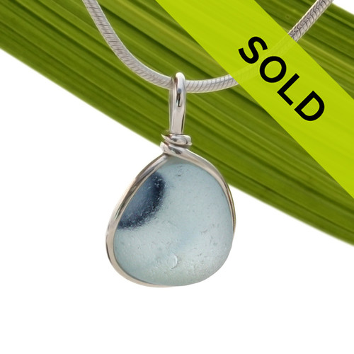 A  bright baby blue in blue base. This piece was once the tip of a punty or pontil rod used to gather and work glass in the kiln. The color being worked was the vivid purplish blue at the side.
Sorry this sea glass necklace pendant has been sold!