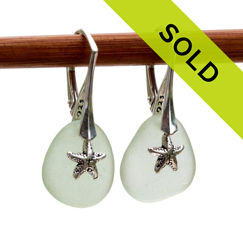 A pair of natural surf tumble sea glass earrings in a seafoam green on sterling leverbacks and detailed with silver starfish charms.
Sorry this sea glass jewelry item is no longer available.