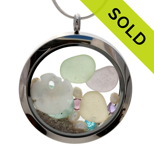 Genuine sea and pale green lavender, yellow and aqua sea glass combined with a real shells, sandollar, pearls, real beach sand , and crystal gems  in this JUMBO 35MM stainless steel locket.
Sorry this Sea Glass Locket is no longer available.