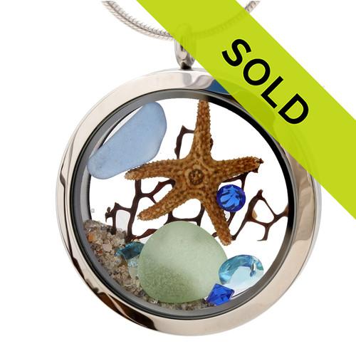 Light Blue and seafoam sea glass combined with a real starfishand a bit of seafan and brightened up a aquamarine and sapphire gems . A great sea glass locket necklace for anyone, specially a March or September Beach Baby!