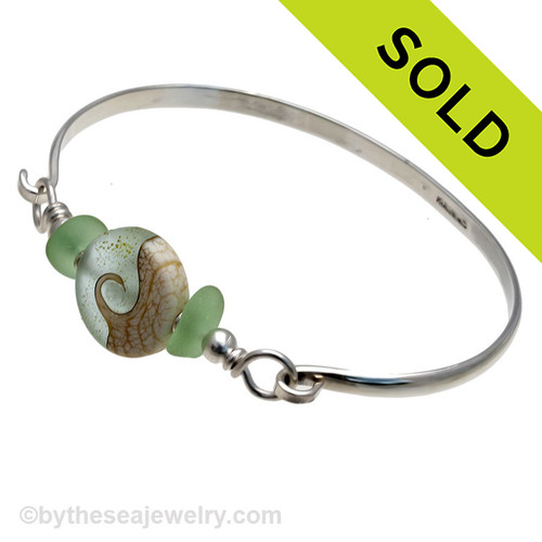 Two pieces of beach found sea glass in vivid yellowy seafoam green on this solid sterling silver half round sea glass bangle bracelet. 
Sorry this Sea Glass Bracelet has been SOLD!