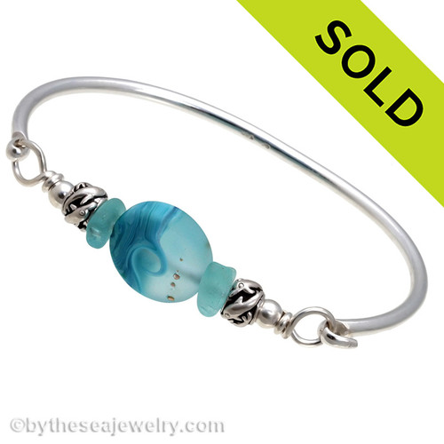 Two pieces of beach found sea glass in vivid tropical aqua on this solid sterling silver FULL ROUND sea glass bangle bracelet. 
Sorry this sea glass jewelry selection has been sold!