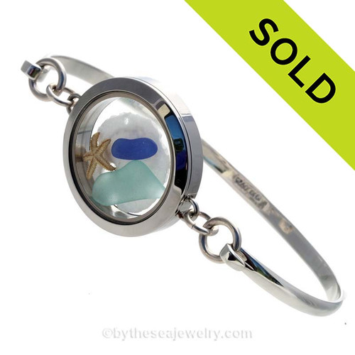 Genuine Sea Glass Locket Bracelet
Tiny cobalt blue and aqua genuine sea glass combined with a small sandollar and a starfish in this one of a kind sea glass bangle bracelet! 
SOLD, sorry this Sea Glass Jewelry selection is no longer available.