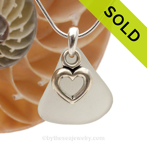 A  perfect piece of pale green genuine sea glass with a solid sterling bail and detailed heart charm.
