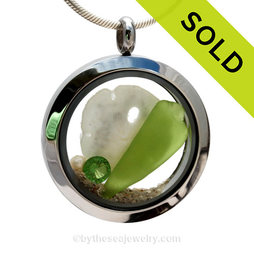 Genuine lime green sea glass piece combined with a small REAL sandollar d a real beach sand in this stainless steel locket.
Finished with a  vivid peridot crystal gem for a bit of beachy bling.
SOLD - Sorry this Sea Glass Locket is NO LONGER AVAILABLE!