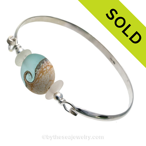 Genuine Pure White Sea Glass Bangle Bracelet set with a handmade lamp work glass wave bead in aqua with sterling end beads on a solid sterling half round premium bangle bracelet.
SOLD - Sorry this Sea Glass Bangle Bracelet is NO LONGER AVAILABLE!