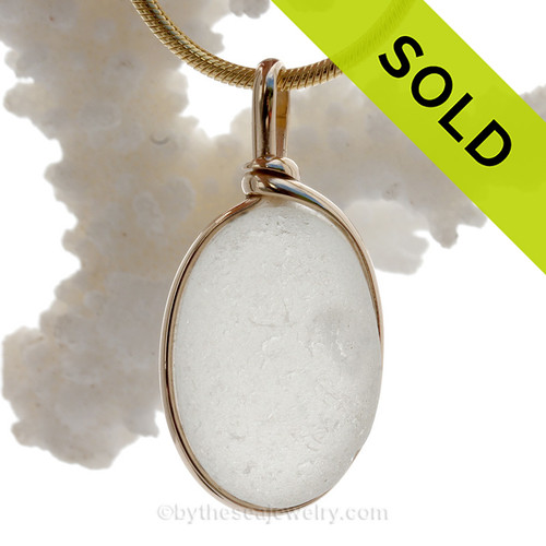 A lovely thick naturally aged pure white with large internal air bubble in a natural sea glass piece set in our Original Wire Bezel setting in 14K Rolled Gold setting.