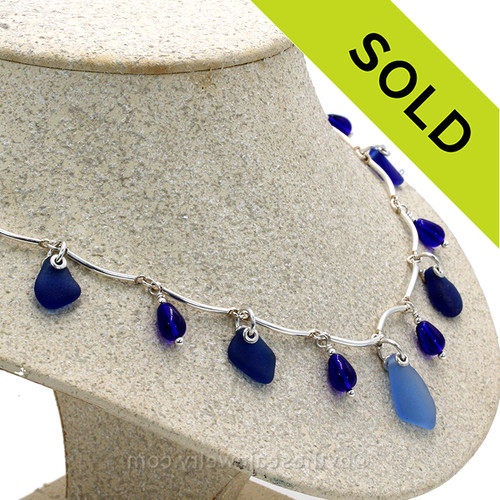 7 pieces of Blue Genuine Beach Collected Sea Glass on a Solid Sterling Silver Curved Bar Necklace with Sterling Beautiful Sterling Teardrop Beads in a elegant necklace.