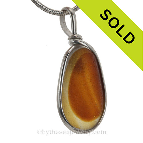 Amber and gold are fused inside this very old English sea glass pendant.