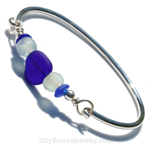 Recycled beads between two blue sea glass pieces in this sterling bangle bracelet!