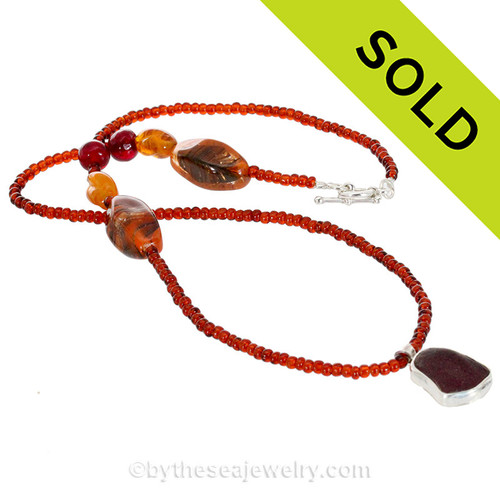 Deep Ruby Red Sea Glass in a basic sterling bezel set on a hand crafted Garnet and Vintage Glass Bead Necklace