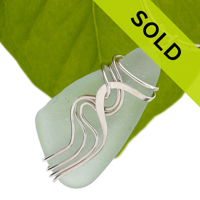 Sorry this pendant has been sold!
A pale seafoam or light green sea glass set in our signature Waves setting. This is an updated version of our popular and secure Squiggles setting. Genuine beach found sea glass UNALTERED from the way it was found on the beach!