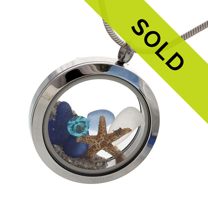 Blue and white natural sea glass are combined with a real starfish and a Zircon crystal gemstone in a stainless steel locket.
Real beach sand completes your own personal "Beach On The Go"!
Sorry this piece has been sold!
