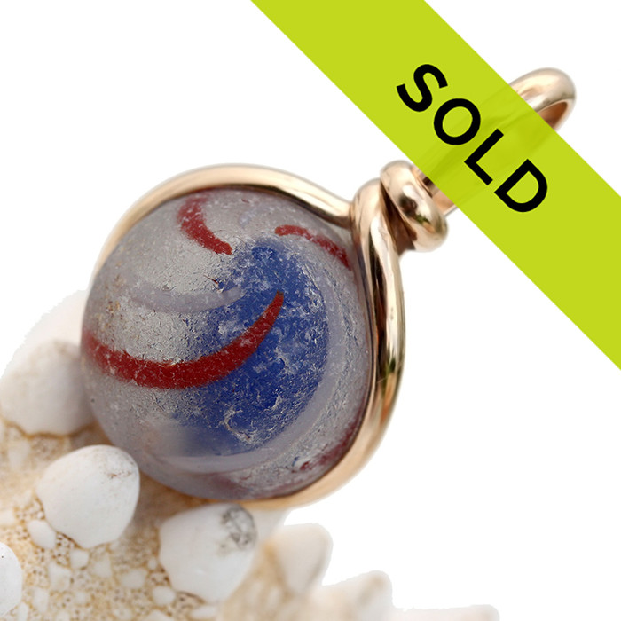 A red white and blue Onion Skin sea glass marble is expertly set in our Original Wire Bezel© setting.
A great top quality sea glass marble, you can see the characteristic "C"'s of genuine sea glass.