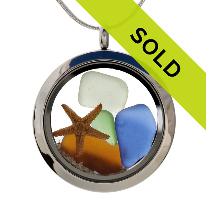 Sea glass in jeweltone colors of green, amber and blues combined with a real starfish and beach sand in this one of a kind stainless steel locket necklace.