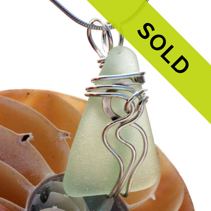 A pale aqua green sea glass set in our signature Waves© necklace pendant setting. Genuine beach found sea glass UNALTERED from the way it was found on the beach!