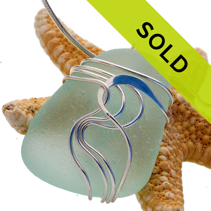 A pale aqua green sea glass set in our signature Waves© setting. Genuine beach found sea glass UNALTERED from the way it was found on the beach!