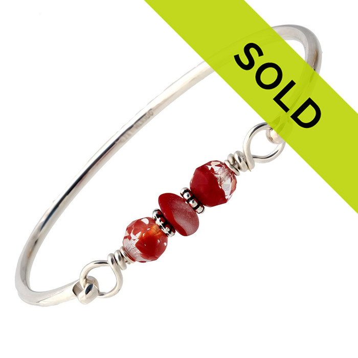 A nice piece of mixed rare red sea glass combined with vintage mixed ruby beads and a large bangle bracelet.
The sea glass is beach found and tumbled only by tide and time found on the beaches of Seaham England.
Sorry this piece has sold!