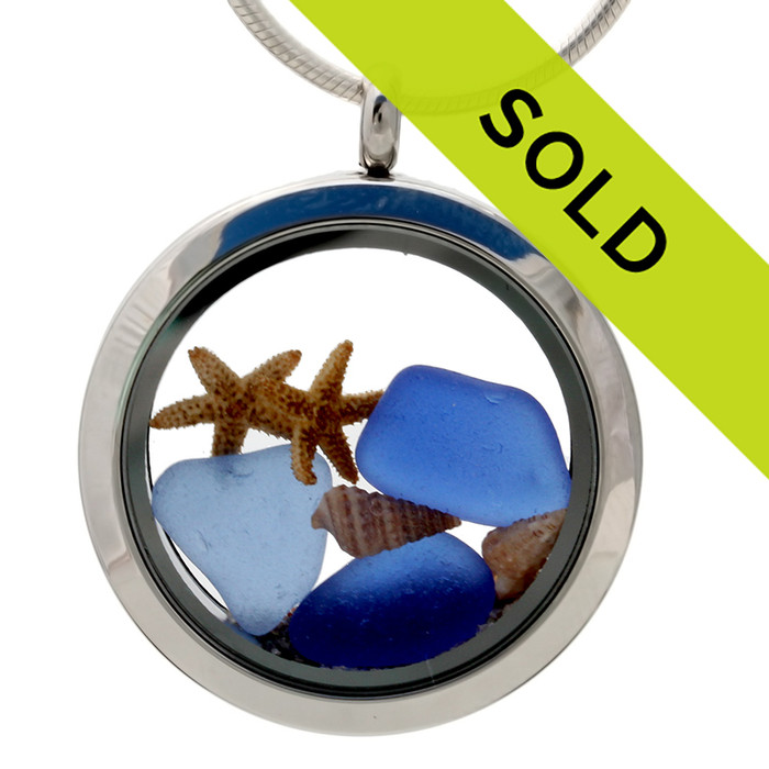 Blue sea glass pieces combined with a real starfish, tiny beach shells and beach sand in this sea glass locket necklace.