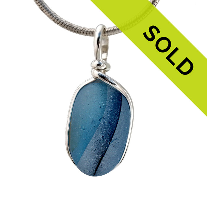 Intense cross sectioned blue multi sea glass found on the beaches of Seaham England set in our Original Wire bezel© pendant setting in sterling silver.