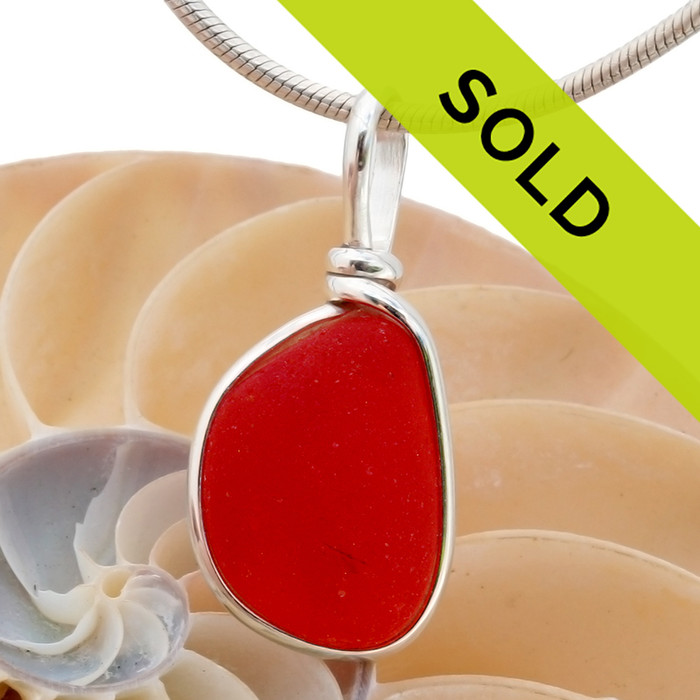 A stunning vivid orange red sea glass piece from England set in our Original Wire Bezel© pendant setting