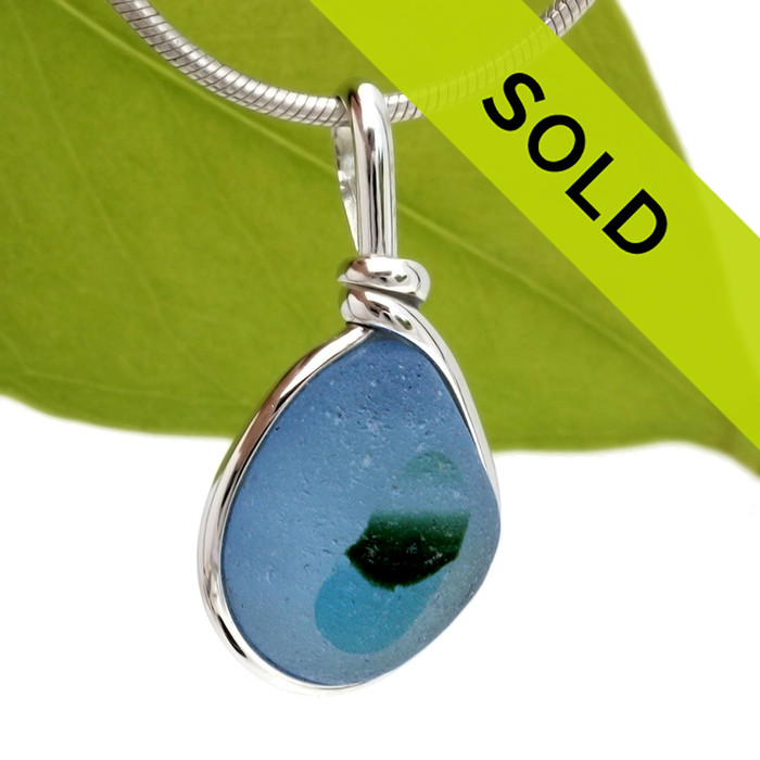 A very bright blue sea glass with spots of aqua and green set in our Original Wire Bezel© pendant setting in sterling silver.

This amazing TOP QUALITY sea glass originates from Seaham England and is the result of years of glass factories discarding their scraps into local waters.

Shown here on our 2mm Snake Chain (Not Included - but recommended and available as an upgrade).