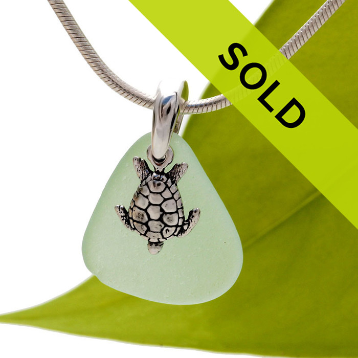 A bright seafoam green piece of TOP QUALITY sea glass set on a solid sterling bail with a sterling sea turtle charm.