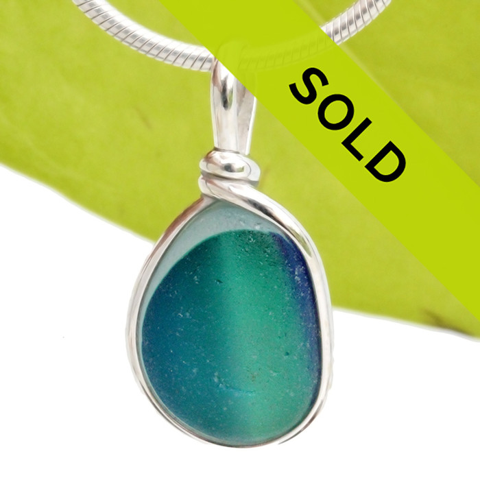 An amazing combination of vivid mixed blue  and aqua green in a light blue base in this very old English Sea Glass piece and set in our Original Wire Bezel© necklace pendant setting