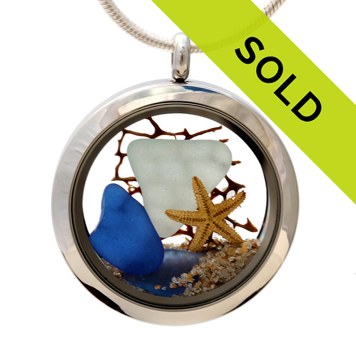 Genuine pale aqua and blue sea glass combined with a vintage sea fan and real shells completed with real beach sand. So sorry this locket has been sold!