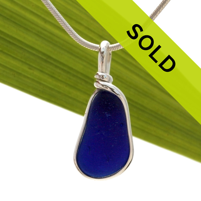 A deep dark blue sea glass necklace pendant in our Original Wire Bezel setting.
This is a thicker piece of English Sea Glass.
Sorry this sea glass jewelry piece has been sold!