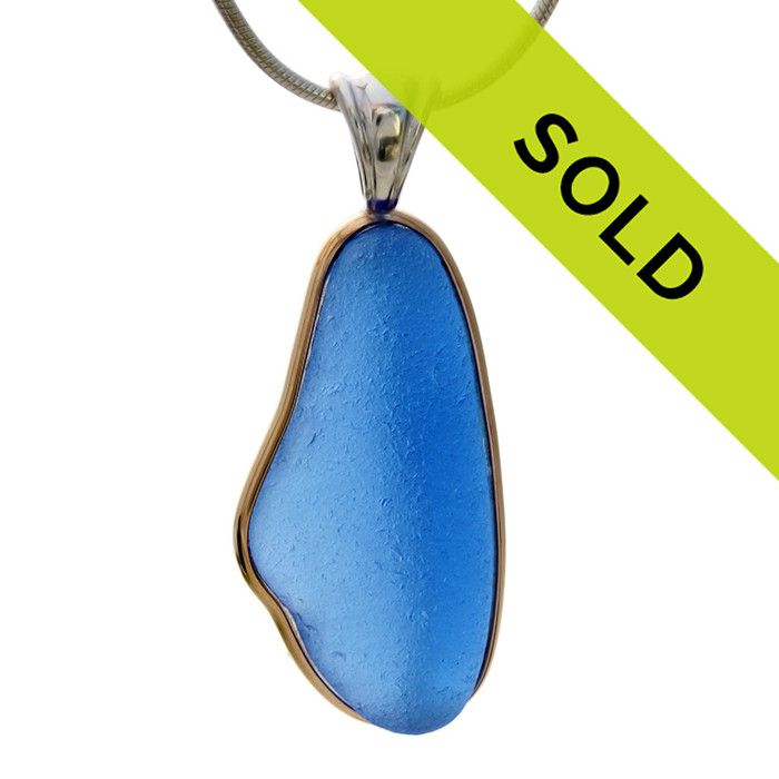 This sea glass a HUGE piece of PERFECT Bright Blue. It is set in a mixed metal gold and sterling silver Deluxe Wire Bezel setting. Very Versatile and elegant. CLASSIC!

This setting leaves this amazing natural sea glass piece just the way it was found on the beach!