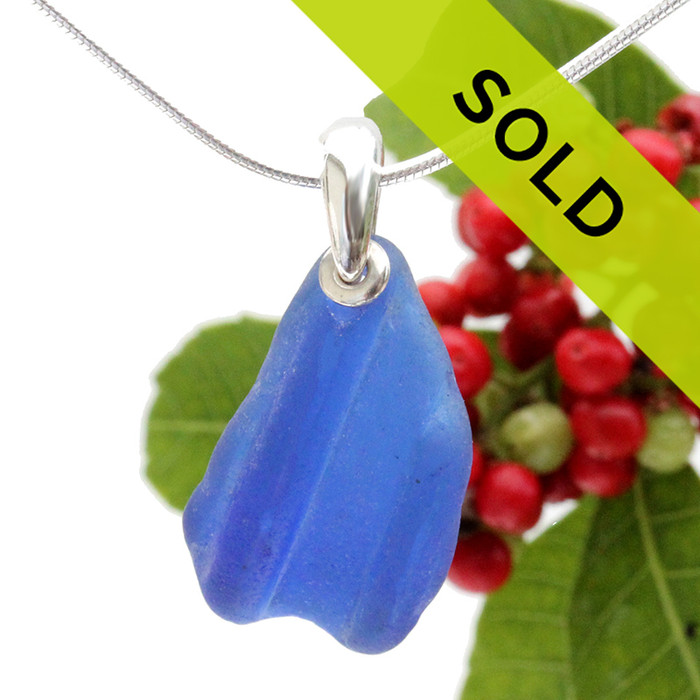 A neat piece of ridged blue sea glass set in a simple sterling silver setting.