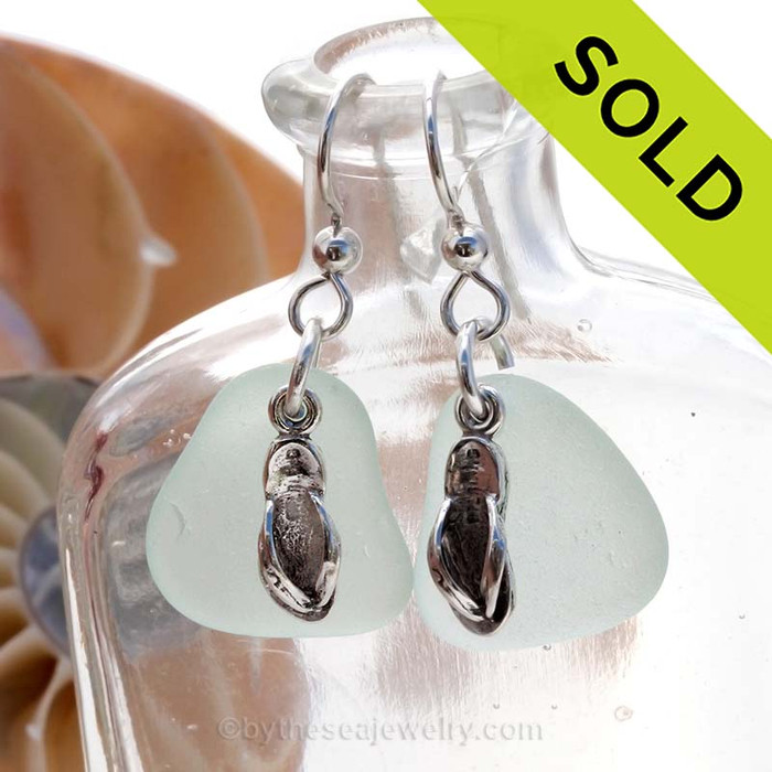 Natural medium large seafoam green sea glass earrings are set with solid sterling flip flop charms and are presented on sterling silver fishook earrings.
Sorry this Sea Glass Jewelry selection is NO LONGER AVAILABLE!