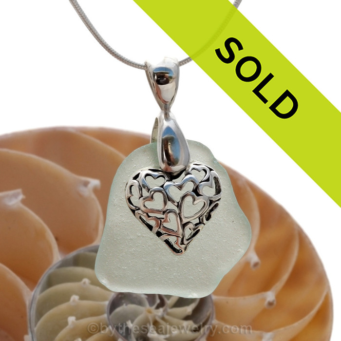A nice piece of natural pale sea green sea glass necklace set on a solid sterling hand cast bail with a sterling silver heart in heart puff charm.
Sorry this sea glass jewelry piece has been sold!