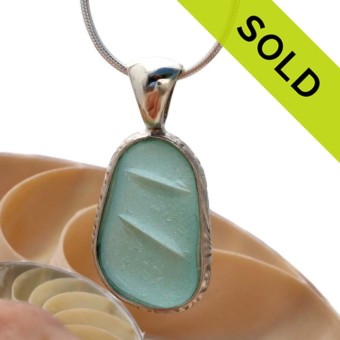 A wonderful shaped embossed piece of Aqua Blue sea glass in our In Our Deluxe Sterling Wire Bezel© necklace pendant.
SOLD - Sorry this Sea Glass Jewelry selection is NO LONGER AVAILABLE!