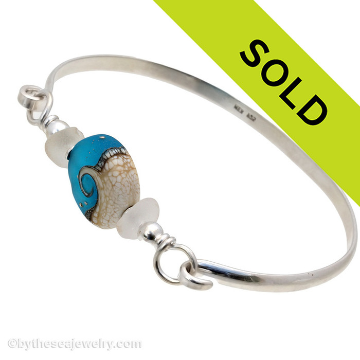 Two pieces of beach found sea glass in vivid tropical aqua on this solid sterling silver half round sea glass bangle bracelet. 
Sorry this sea glass jewelry piece has been sold!