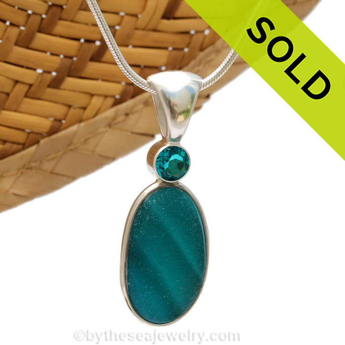 This beautiful HIGHLY RARE Seaham sea glass piece is set in our Deluxe Wire Bezel© pendant setting. This incorporates a Paraiba gem in a tube bezel setting for a touch of elegance.
Sorry this Ultra Rare Sea Glass Jewelry piece has been sold!